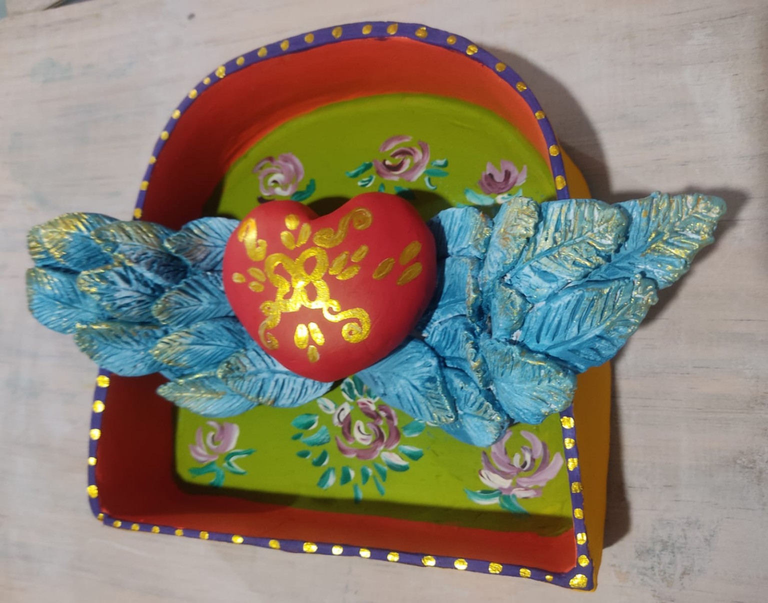 Vista superior del corazón, las alas y las flores pintadas