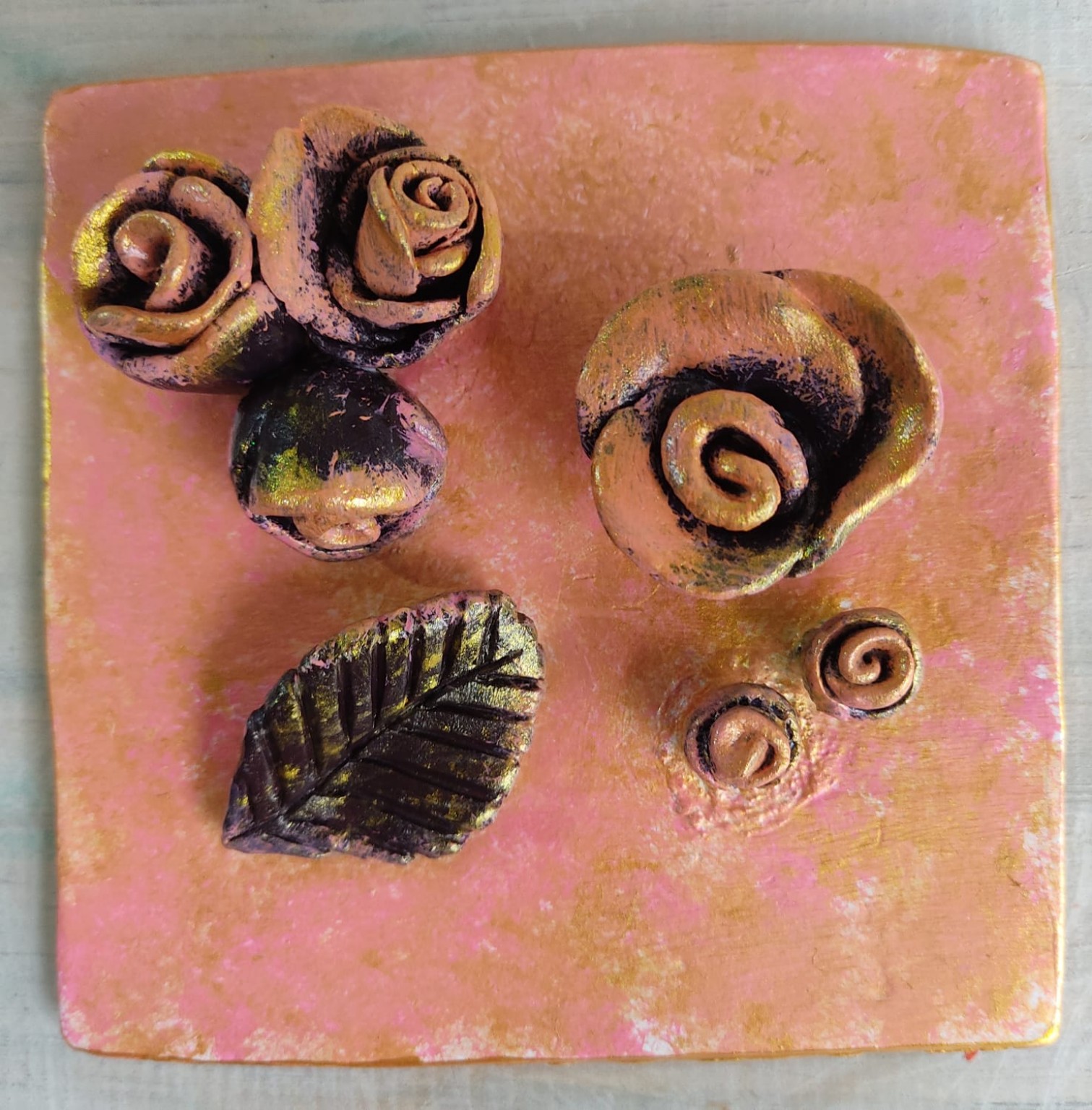 Relieve rosado terminado con flores, hoja y espirales