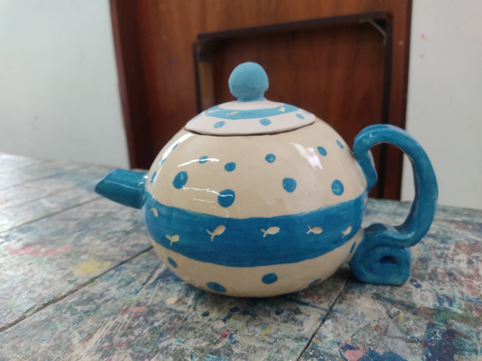 Tetera terminada con una franja azul y pequeños peces