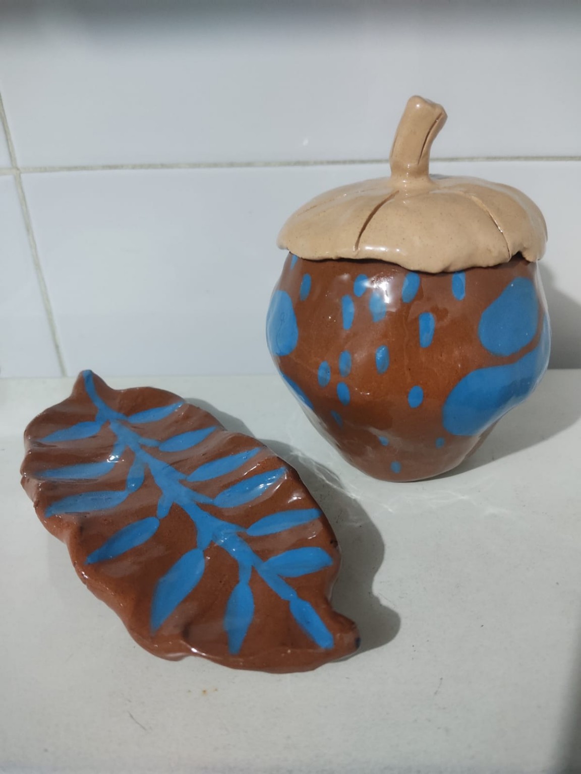 Vista frontal de la fruta y la hoja terminadas con puntos y trazos de engobe azul