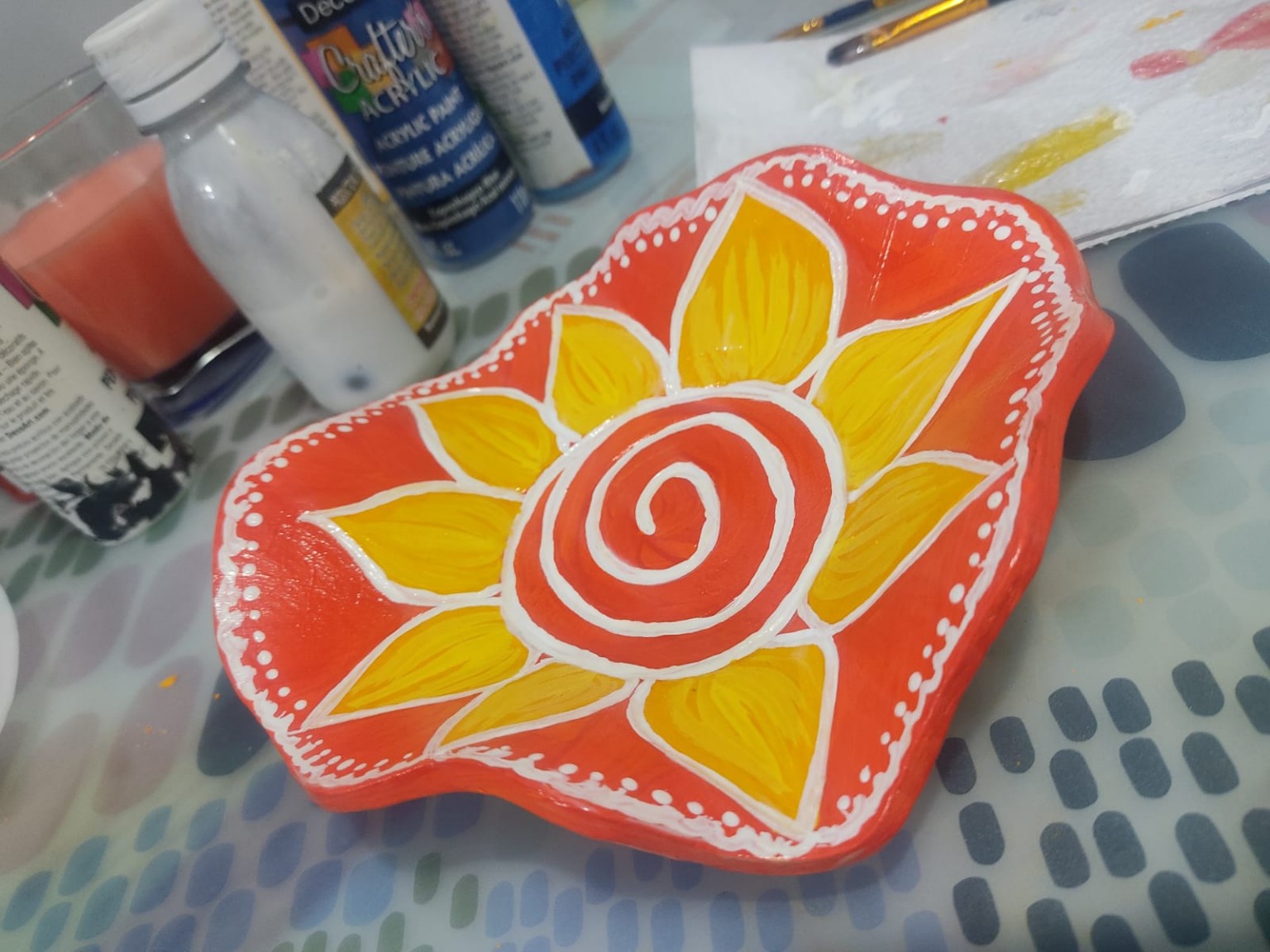 Plato doble faz terminado con girasol amarillo sobre fondo naranja